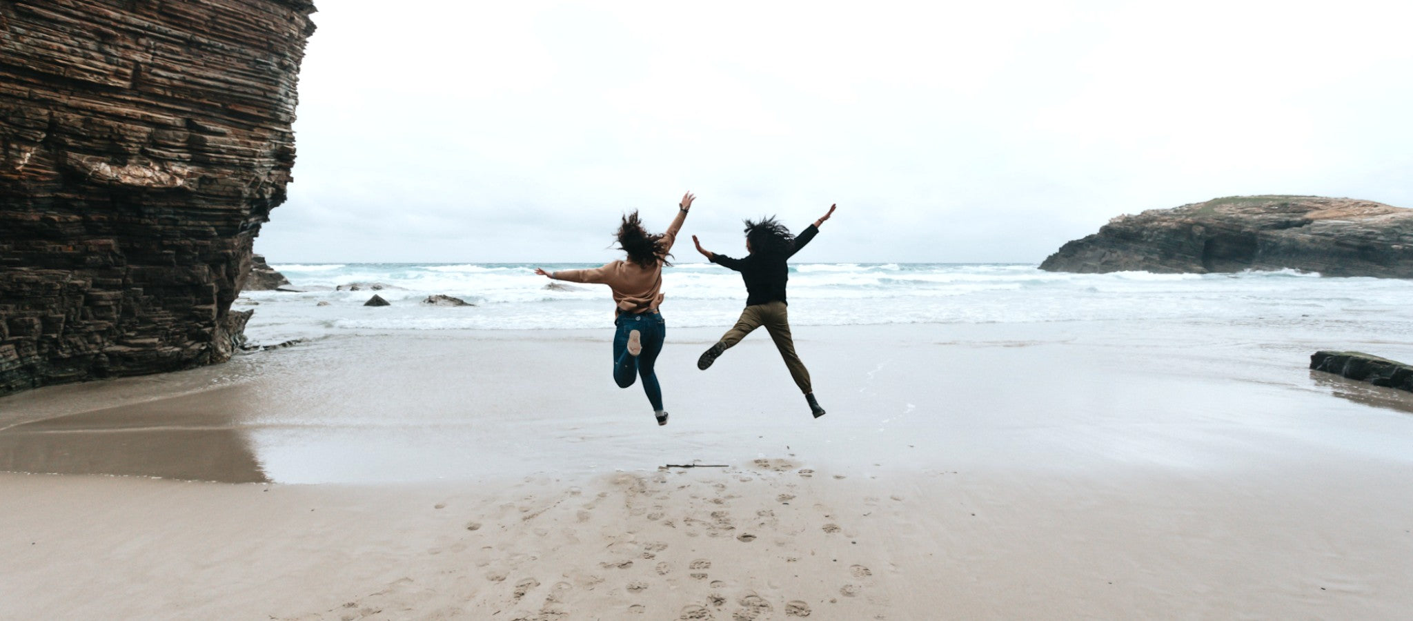 two-people-jump-high-on-a-sandy-beach-Photoroom_1.jpg